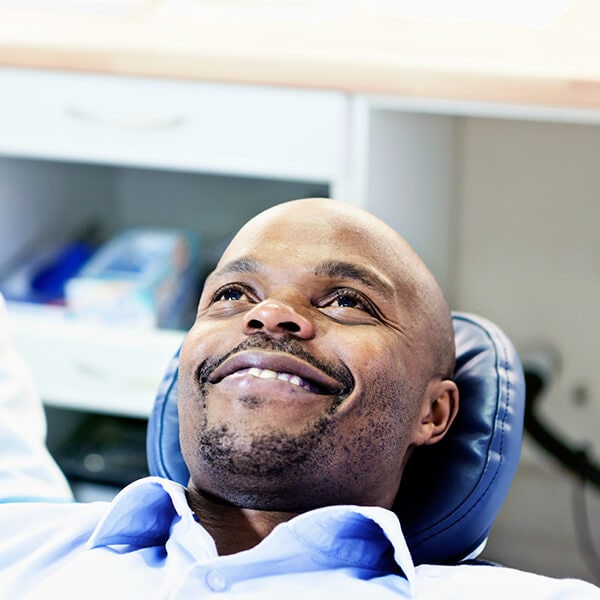 A mature man relaxed in the dentist's chair while smiling