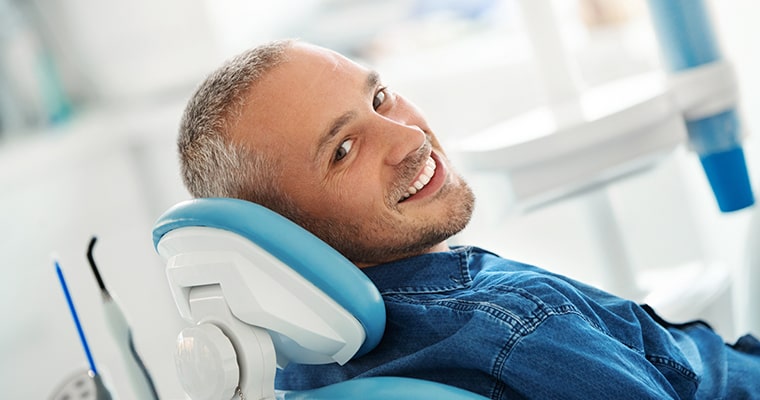 A man looking back while sitting in dental chair.